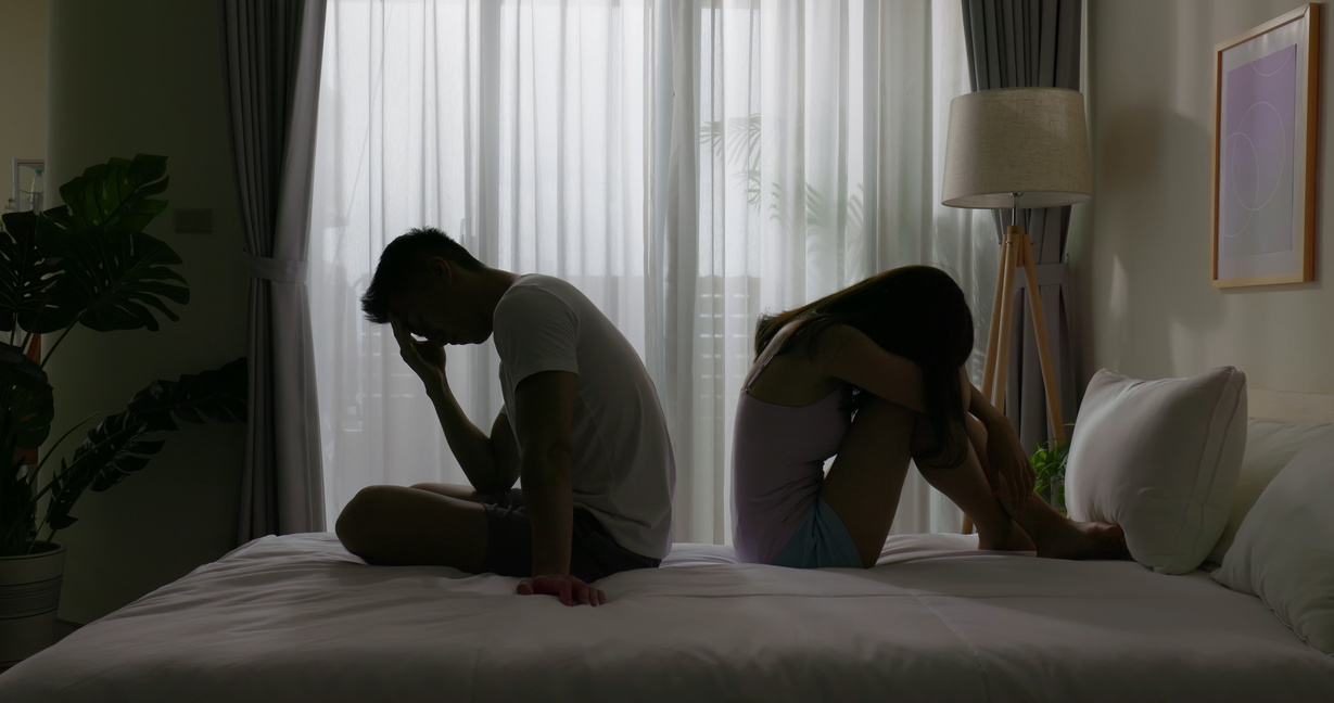 Black and white photo of a male and female couple facing away from one another like a broken up couple.